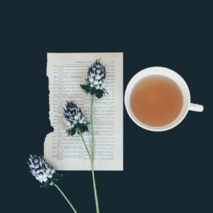 Tee in Tasse und Blatt Papier mit Blumen