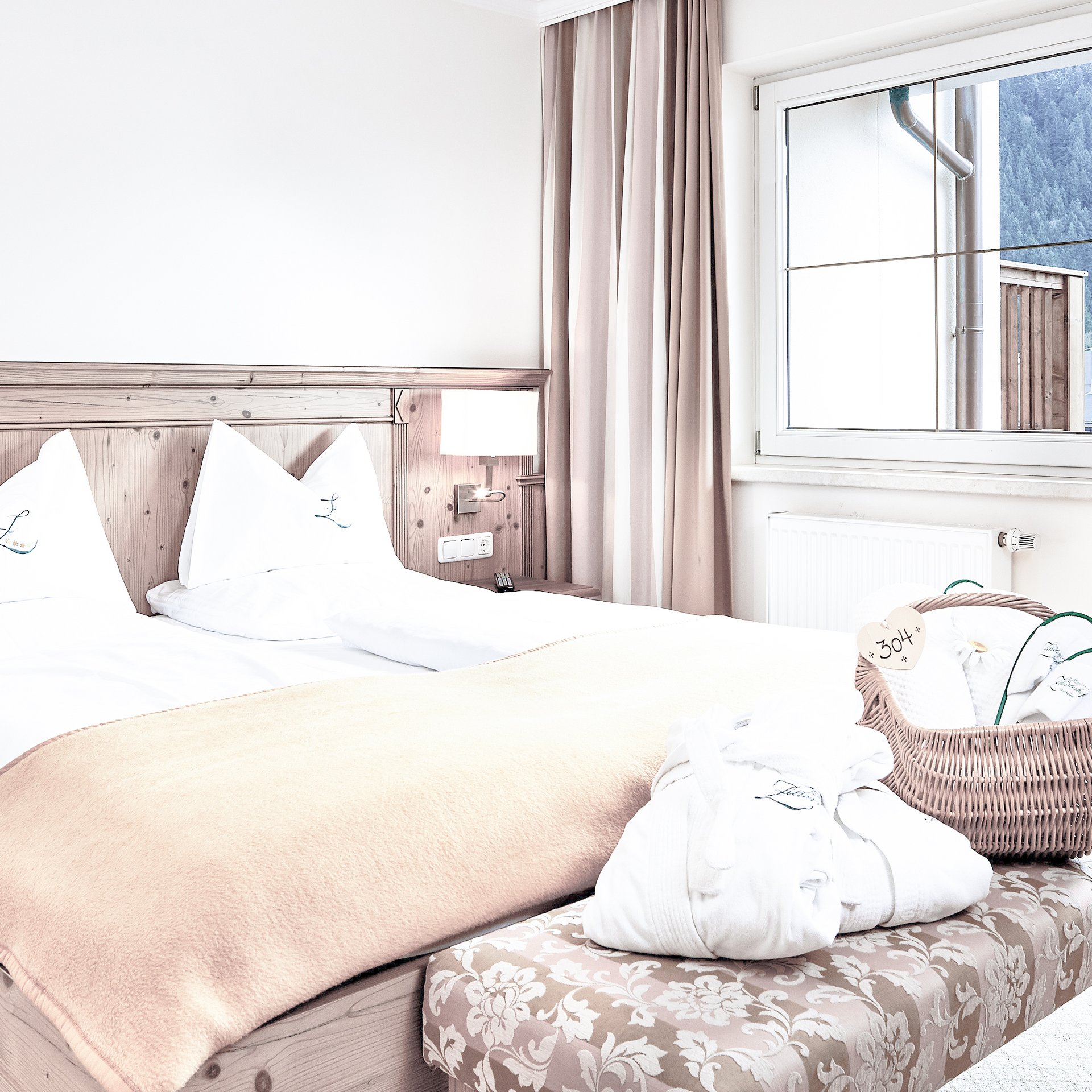 Comfy Alpine Style Bright room with wooden bed, window view of the mountains, basket with slippers.