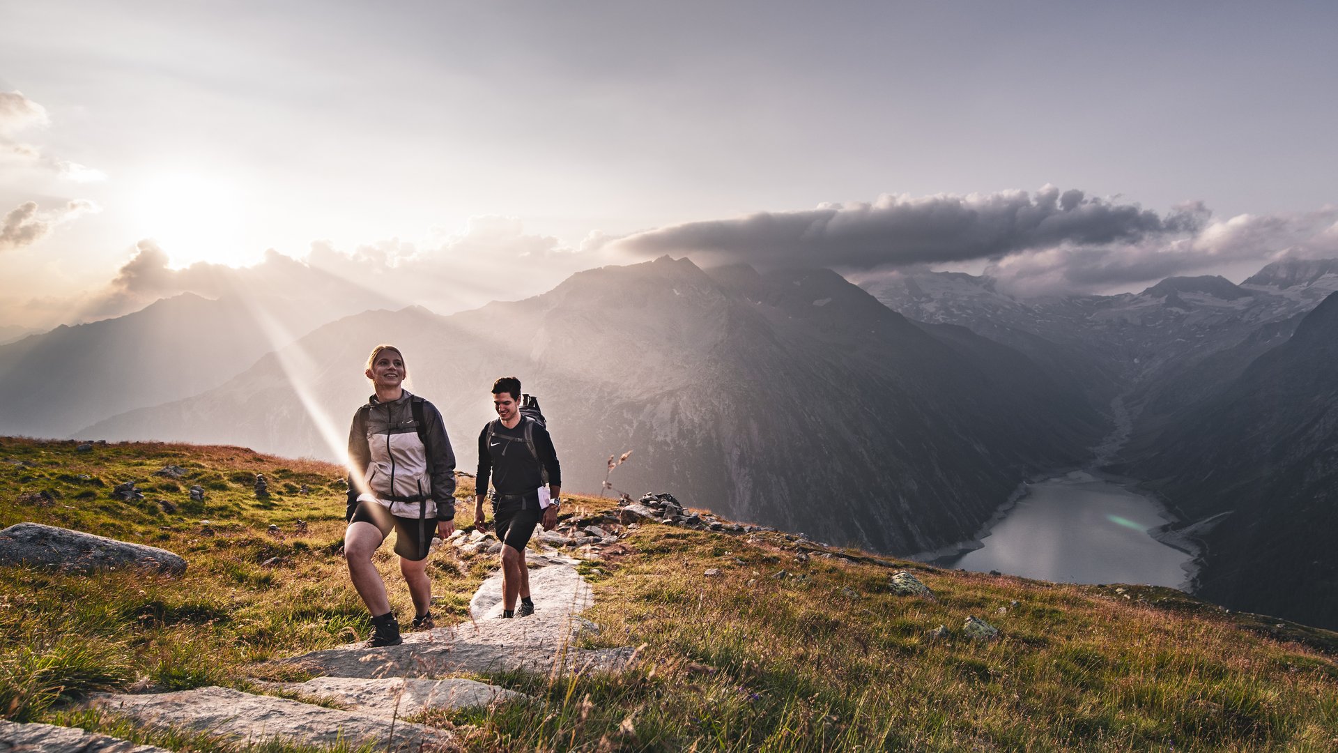 Sonnenaufgangswanderung in den Alpen Zwei Wanderer genießen den Sonnenaufgang in den beeindruckenden Alpen.